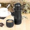 Black portable espresso coffee maker standing upright showing its ergonomic pump button