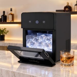 Luvimo black plastic ice ball maker with clear door, producing spherical ice for cocktails on a bar counter.