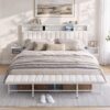 White upholstered bed frame with channel tufting, built-in shelves, and charging ports for a modern bedroom.