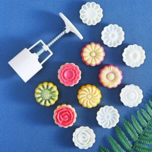 White plastic mooncake press with assorted colorful flower-shaped molds for baking traditional pastries.