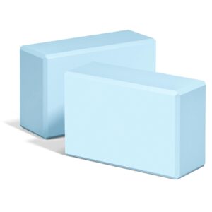 Two light blue foam yoga blocks with beveled edges, for support and stability during yoga and Pilates.