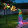 Solar hummingbird watering can garden stake with colorful LED string lights, metal, for outdoor decor.