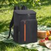 Black insulated cooler backpack, durable nylon, orange zipper, for picnics and outdoor activities.