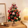Miniature artificial Christmas tree with red/gold ornaments, plaid bow, and star topper for tabletop decor.