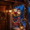 Lighted Christmas wreath with Santa, reindeer, snowman, red bells, and "Merry Christmas" sign for outdoor decor.