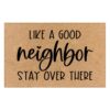 Tan coir doormat with "LIKE A GOOD neighbor STAY OVER THERE" in black text, for home entryways.