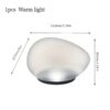 Warm light, egg-shaped frosted glass lamp with black base, for ambient lighting.