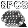 8PCS silver metal solar ground lights with 12 bright LEDs, black solar panel, for outdoor garden path lighting.