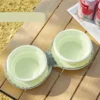 Two light green silicone collapsible pet bowls for travel, camping, or outdoor use.