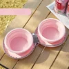 Two pink silicone collapsible pet bowls in a gray zippered case, for travel feeding.