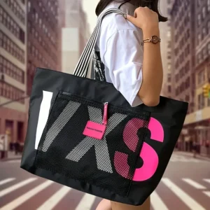 Black nylon tote bag with white/pink "IXS" graphic, mesh pocket, striped strap, for travel/gym.