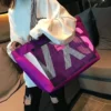 Purple nylon tote bag with black mesh front pocket, white "MK" letters, and pink tag, for everyday use.