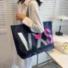 Navy blue nylon tote bag with white/pink "VKS" logo, mesh pocket, and striped strap for everyday use.