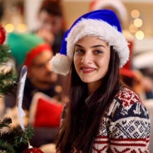 Blue Plush Santa Hat With White Faux Fur Trim And Pom-Pom, Worn By A Woman At A Christmas Party.