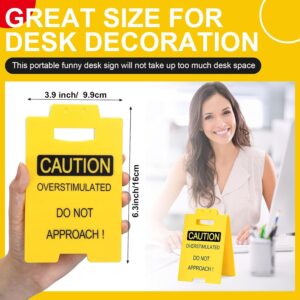 Yellow plastic "CAUTION OVERSTIMULATED DO NOT APPROACH!" desk sign, 6.3x3.9 inches, for office decor.