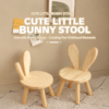 Natural wood kids' bunny ear stool, light brown, round seat, 4 sturdy legs, for children's room or play area.
