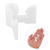White plastic U-shaped car door panel retainer clip, shown with smaller clips in hand, for automotive fastening.