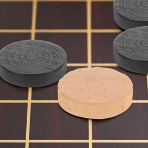Wooden Checker Pieces, Round, Flat, One Natural Wood Color, Three Black, Textured Top, On A Dark Wood Board.