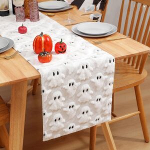 White fuzzy knitted Halloween table runner with 3D ghost pattern, for festive dining decor.
