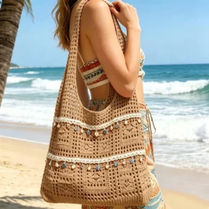 Brown crochet beach tote bag with shell and disc embellishments, for summer outings.