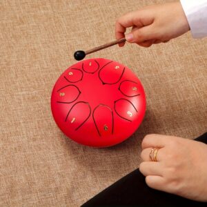 Red Steel Tongue Drum With Numbered Tongues, Played With A Mallet For Meditation And Relaxation.
