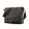 Dark gray canvas messenger bag with brown strap, front flap, and metal buckle for daily use.