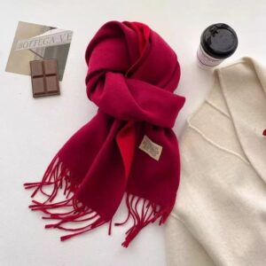 Soft, thick red wool scarf with fringe, folded, for winter warmth and style.