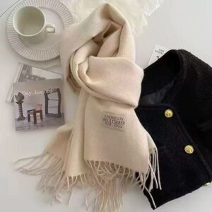Cream cashmere blend scarf with fringe, "UNDRESON REGITSERED EST. 2023" label, for winter fashion.