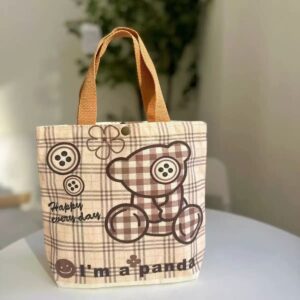 Beige plaid canvas tote bag with brown teddy bear, buttons, and 