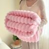 Pink faux fur blanket with wavy textured stripes, soft and plush, for cozy home decor.