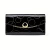 Black patent leather women's wallet with embossed circles, gold clasp, and heart detail for everyday use.