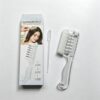 Clear plastic scalp liquid comb with white bristles and dropper for hair oil application.